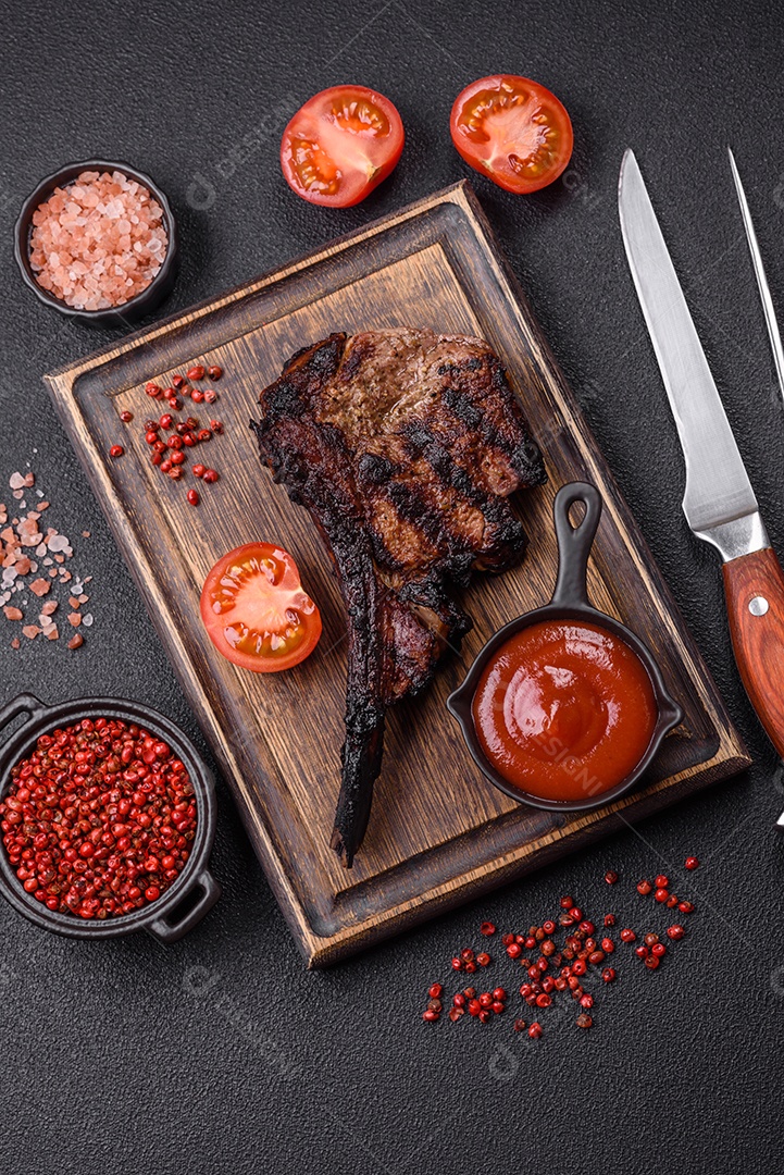 Bife fresco, suculento e delicioso em um fundo escuro. Prato de carne com especiarias e ervas
