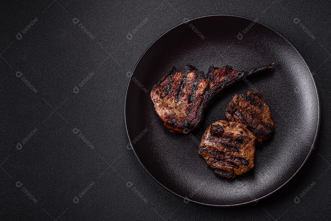 Bife fresco, suculento e delicioso em um fundo escuro. Prato de carne com especiarias e ervas