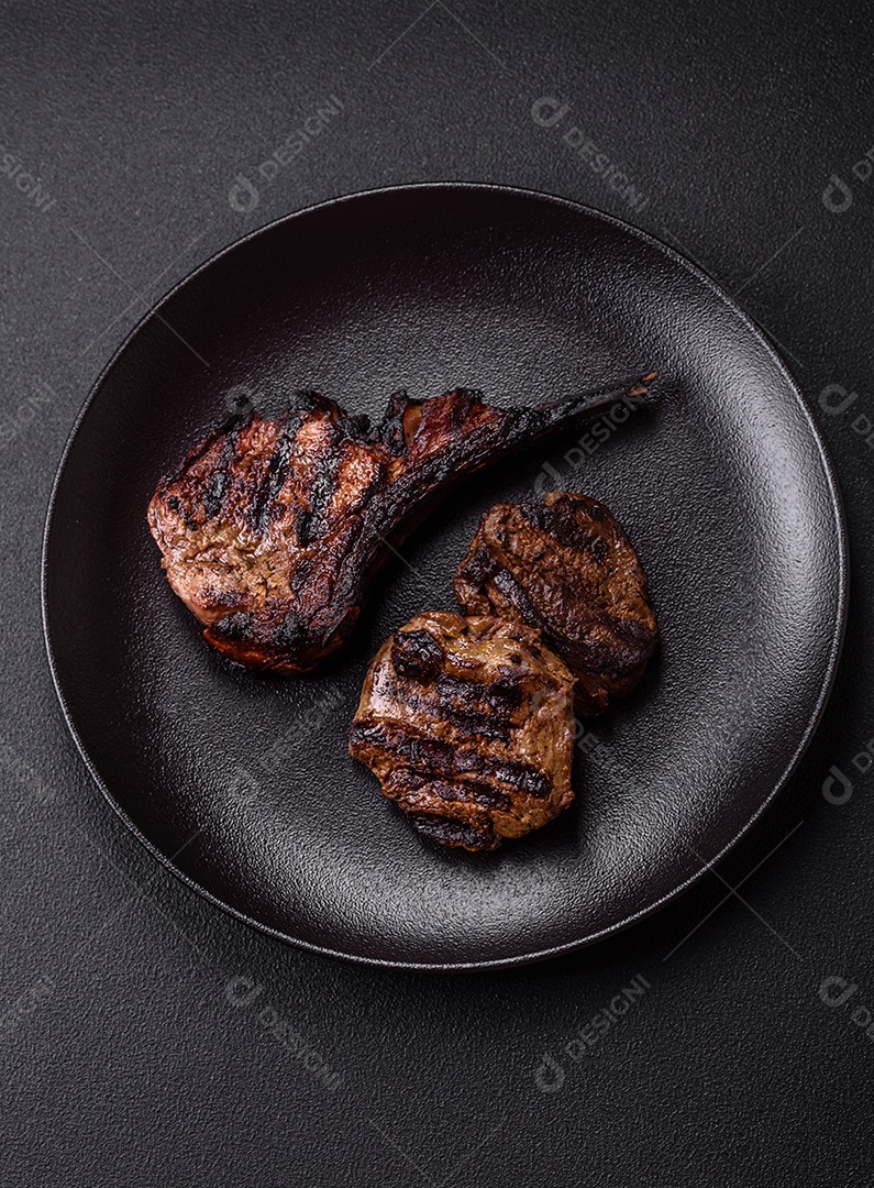 Bife fresco, suculento e delicioso em um fundo escuro. Prato de carne com especiarias e ervas