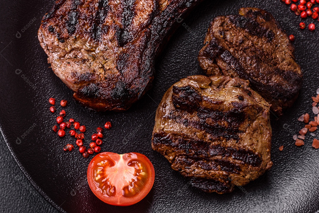 Bife fresco, suculento e delicioso em um fundo escuro. Prato de carne com especiarias e ervas