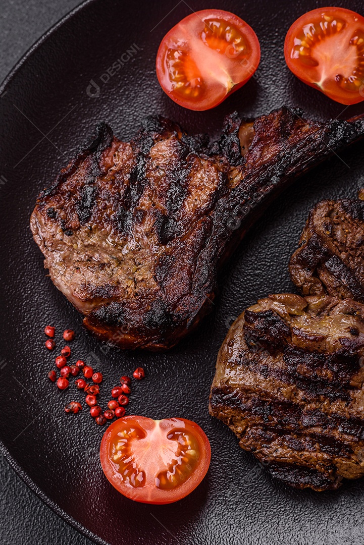 Bife fresco, suculento e delicioso em um fundo escuro. Prato de carne com especiarias e ervas