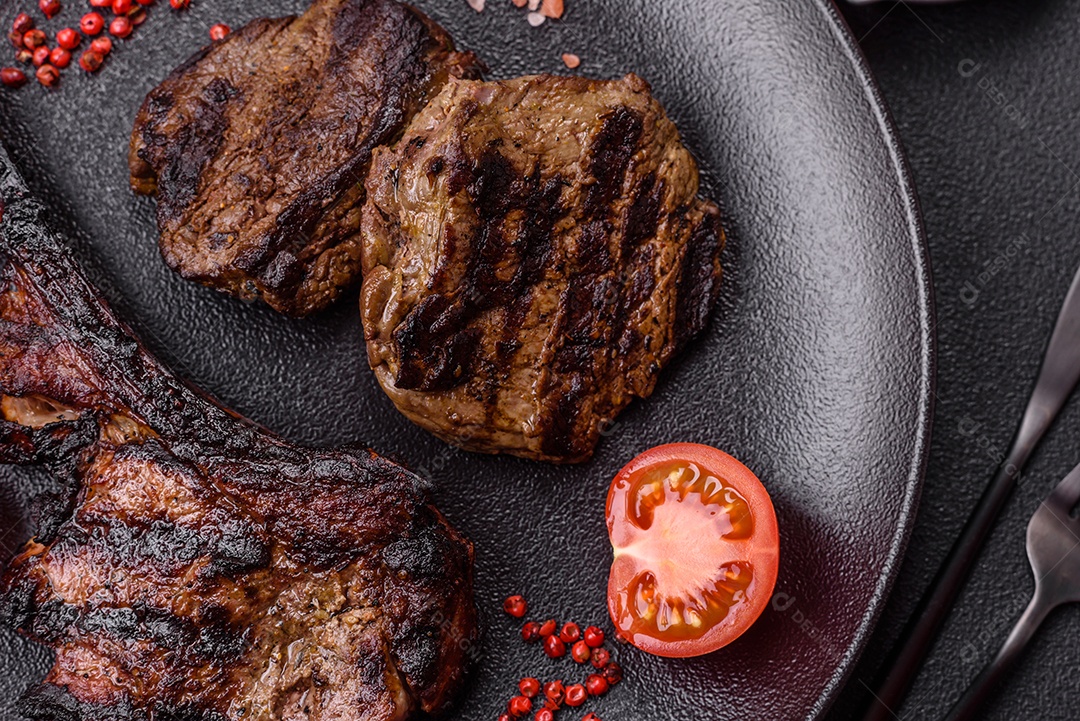 Bife fresco, suculento e delicioso em um fundo escuro. Prato de carne com especiarias e ervas
