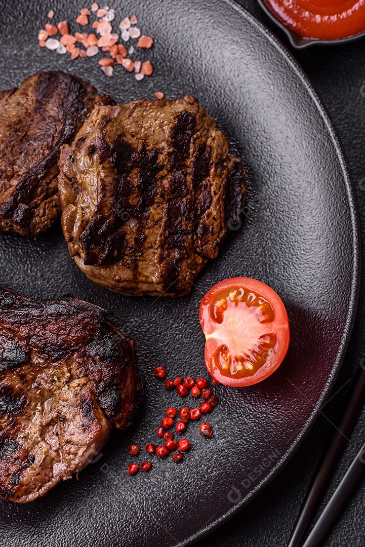 Bife fresco, suculento e delicioso em um fundo escuro. Prato de carne com especiarias e ervas