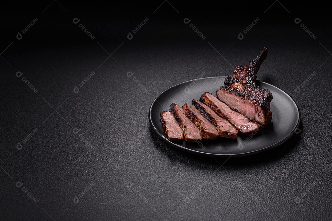 Bife fresco, suculento e delicioso em um fundo escuro. Prato de carne com especiarias e ervas