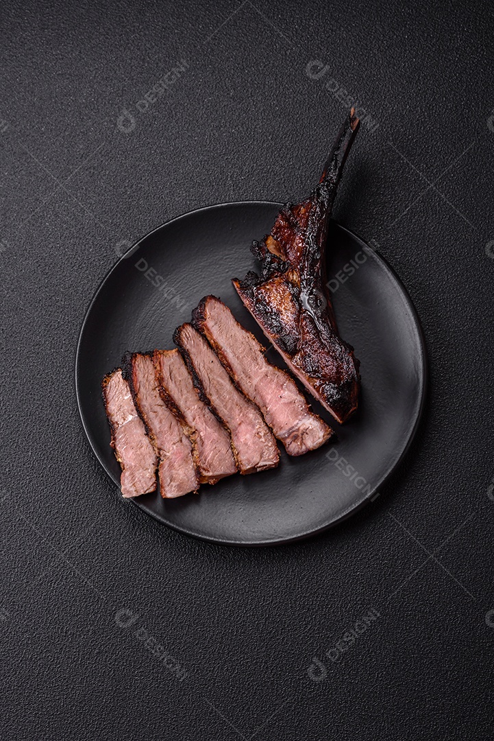 Bife fresco, suculento e delicioso em um fundo escuro. Prato de carne com especiarias e ervas