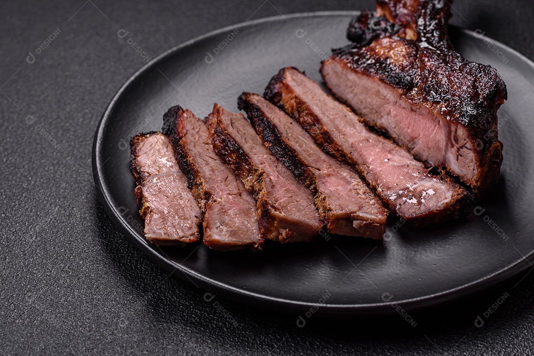 Bife fresco, suculento e delicioso em um fundo escuro. Prato de carne com especiarias e ervas