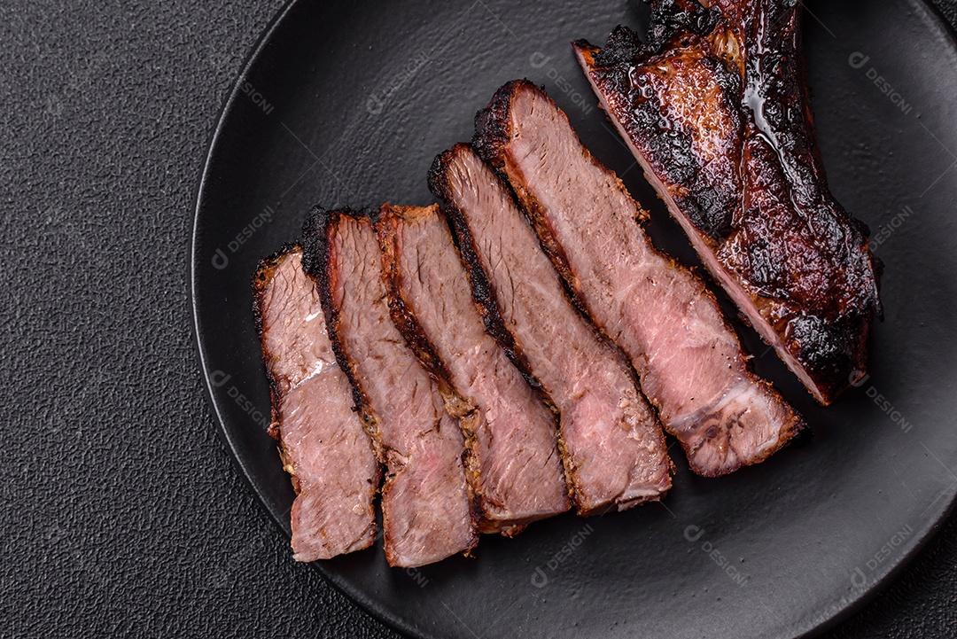 Bife fresco, suculento e delicioso em um fundo escuro. Prato de carne com especiarias e ervas
