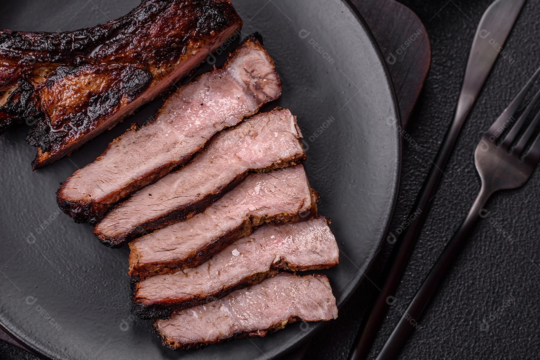 Bife fresco, suculento e delicioso em um fundo escuro. Prato de carne com especiarias e ervas