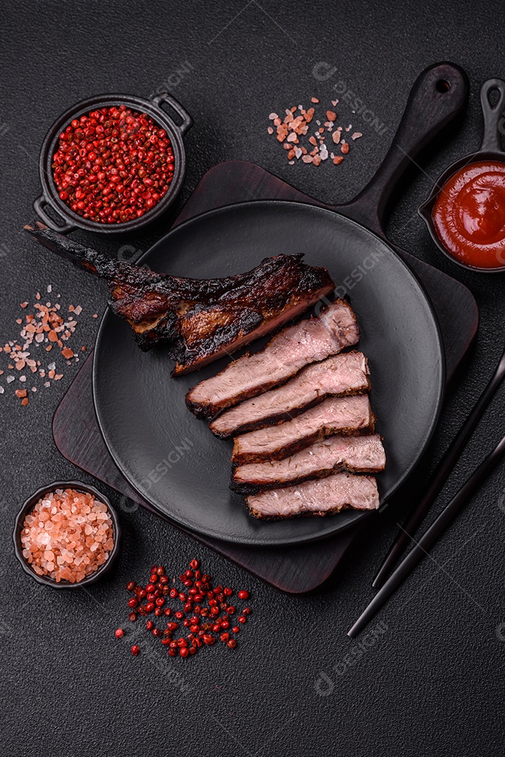 Bife fresco, suculento e delicioso em um fundo escuro. Prato de carne com especiarias e ervas