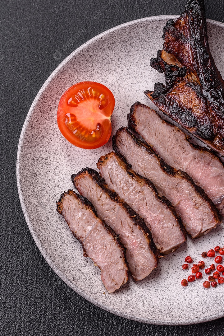 Bife fresco, suculento e delicioso em um fundo escuro. Prato de carne com especiarias e ervas