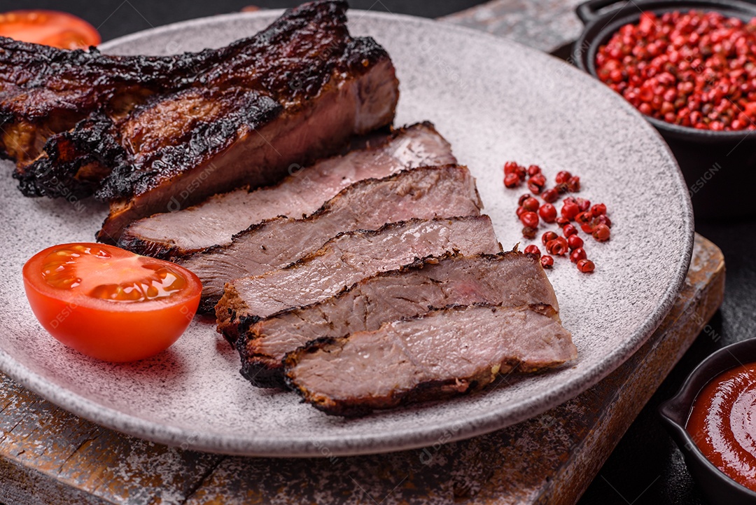 Bife fresco, suculento e delicioso em um fundo escuro. Prato de carne com especiarias e ervas