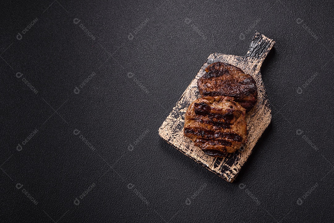 Bife fresco, suculento e delicioso em um fundo escuro. Prato de carne com especiarias e ervas