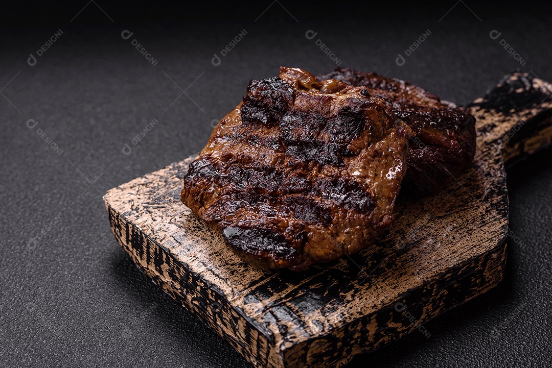 Bife fresco, suculento e delicioso em um fundo escuro. Prato de carne com especiarias e ervas