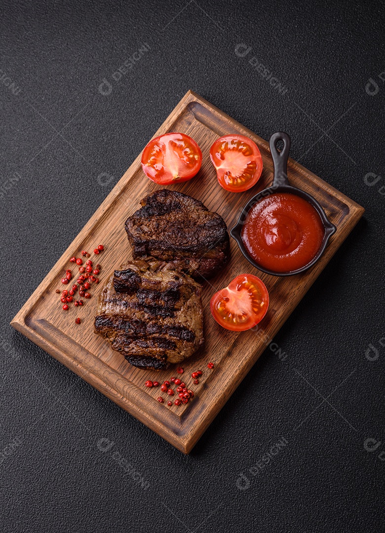 Bife fresco, suculento e delicioso em um fundo escuro. Prato de carne com especiarias e ervas