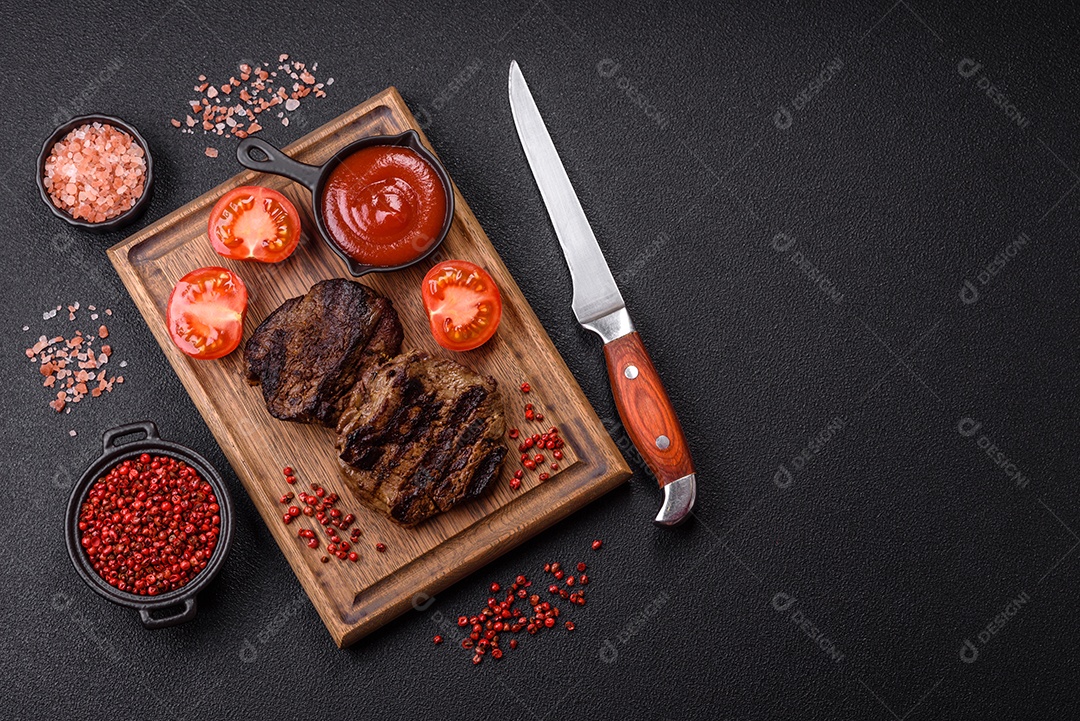 Bife fresco, suculento e delicioso em um fundo escuro. Prato de carne com especiarias e ervas
