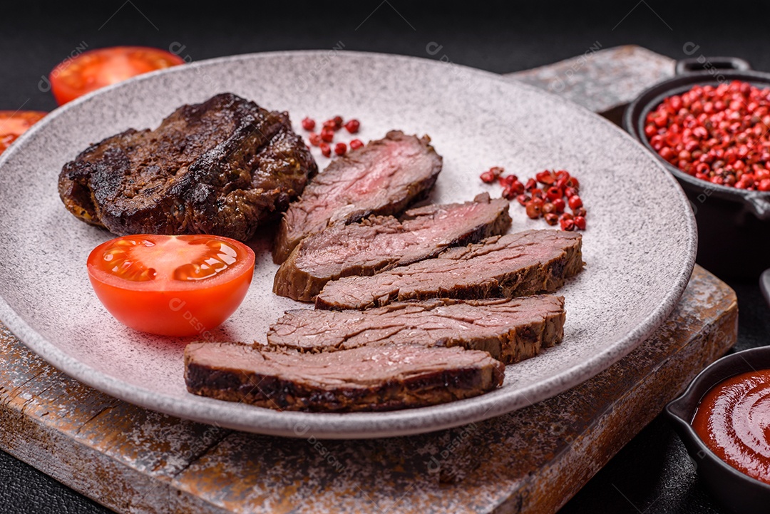 Bife fresco, suculento e delicioso em um fundo escuro. Prato de carne com especiarias e ervas