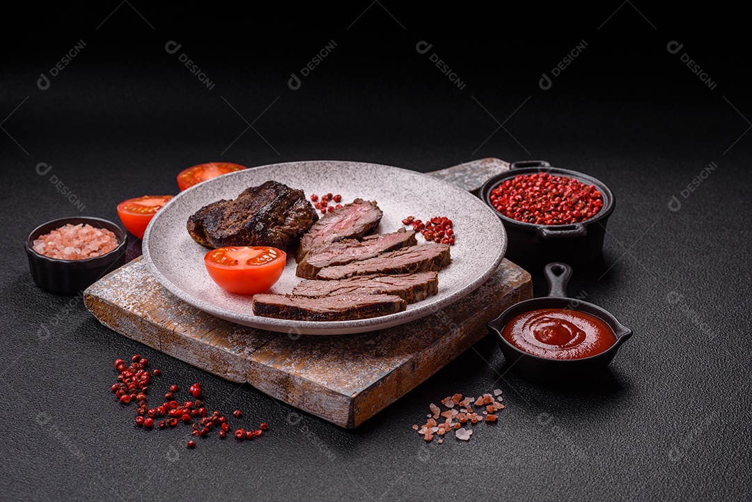 Bife fresco, suculento e delicioso em um fundo escuro. Prato de carne com especiarias e ervas