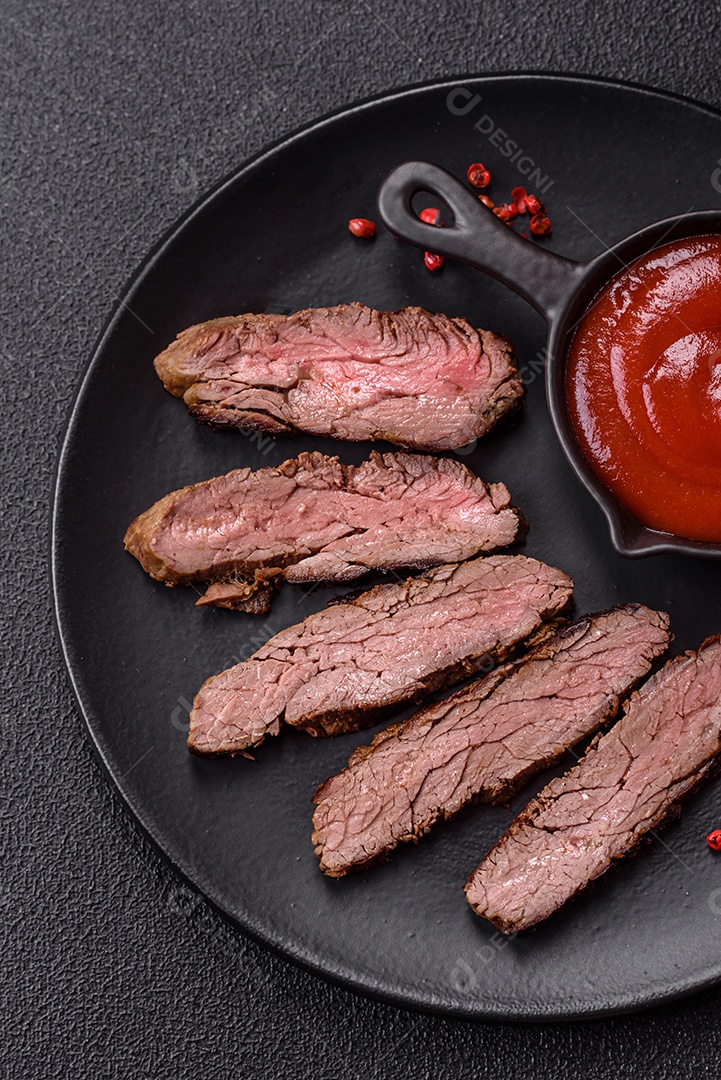 Bife fresco, suculento e delicioso em um fundo escuro. Prato de carne com especiarias e ervas