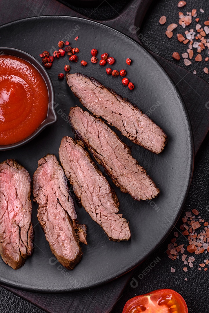 Bife fresco, suculento e delicioso em um fundo escuro. Prato de carne com especiarias e ervas