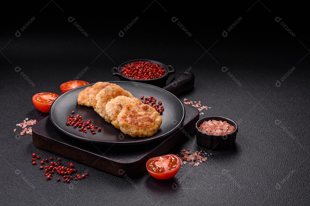 Deliciosas costeletas de peixe picado frito fresco com especiarias e ervas sobre um fundo escuro de concreto