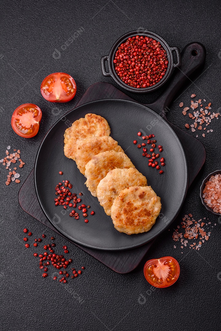 Deliciosas costeletas de peixe picado frito fresco com especiarias e ervas sobre um fundo escuro de concreto