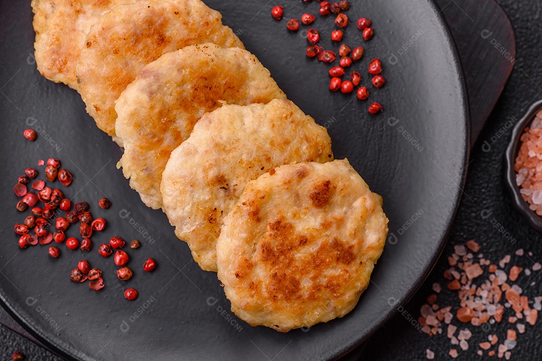 Deliciosas costeletas de peixe picado frito fresco com especiarias e ervas sobre um fundo escuro de concreto