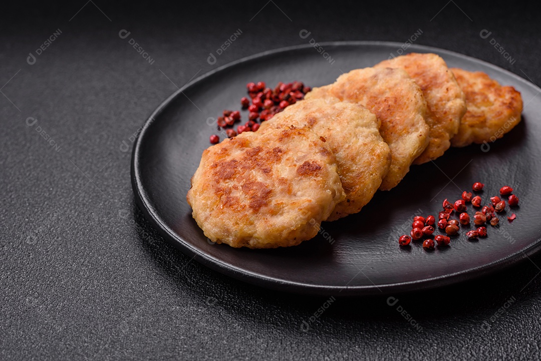 Deliciosas costeletas de peixe picado frito fresco com especiarias e ervas sobre um fundo escuro de concreto
