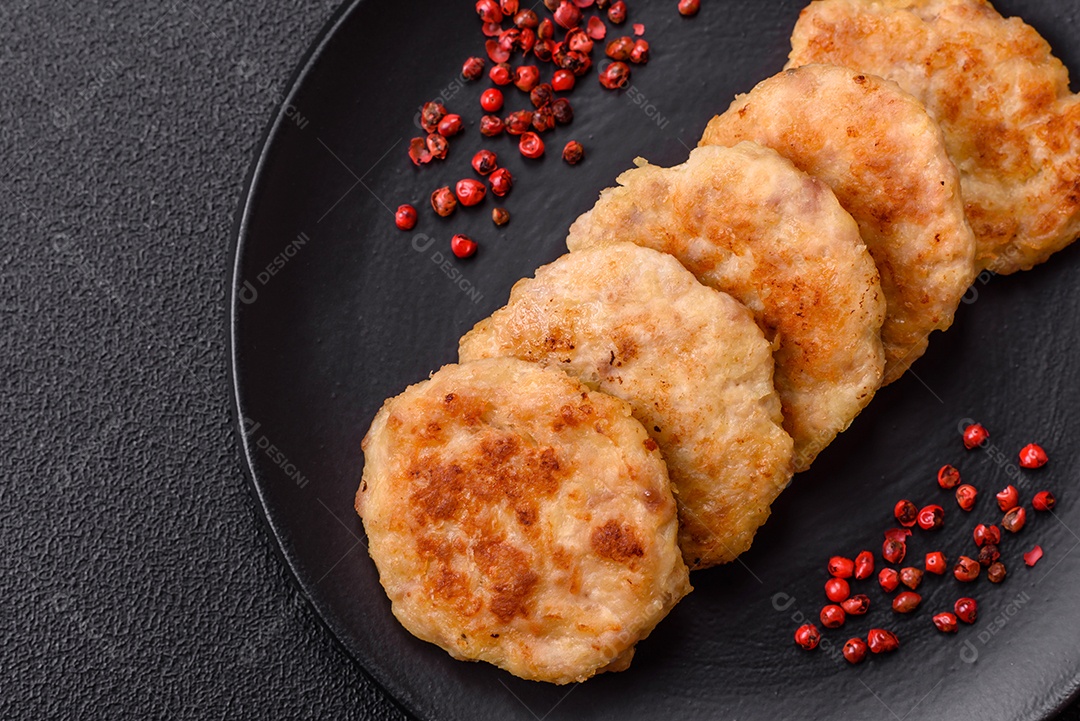 Deliciosas costeletas de peixe picado frito fresco com especiarias e ervas sobre um fundo escuro de concreto