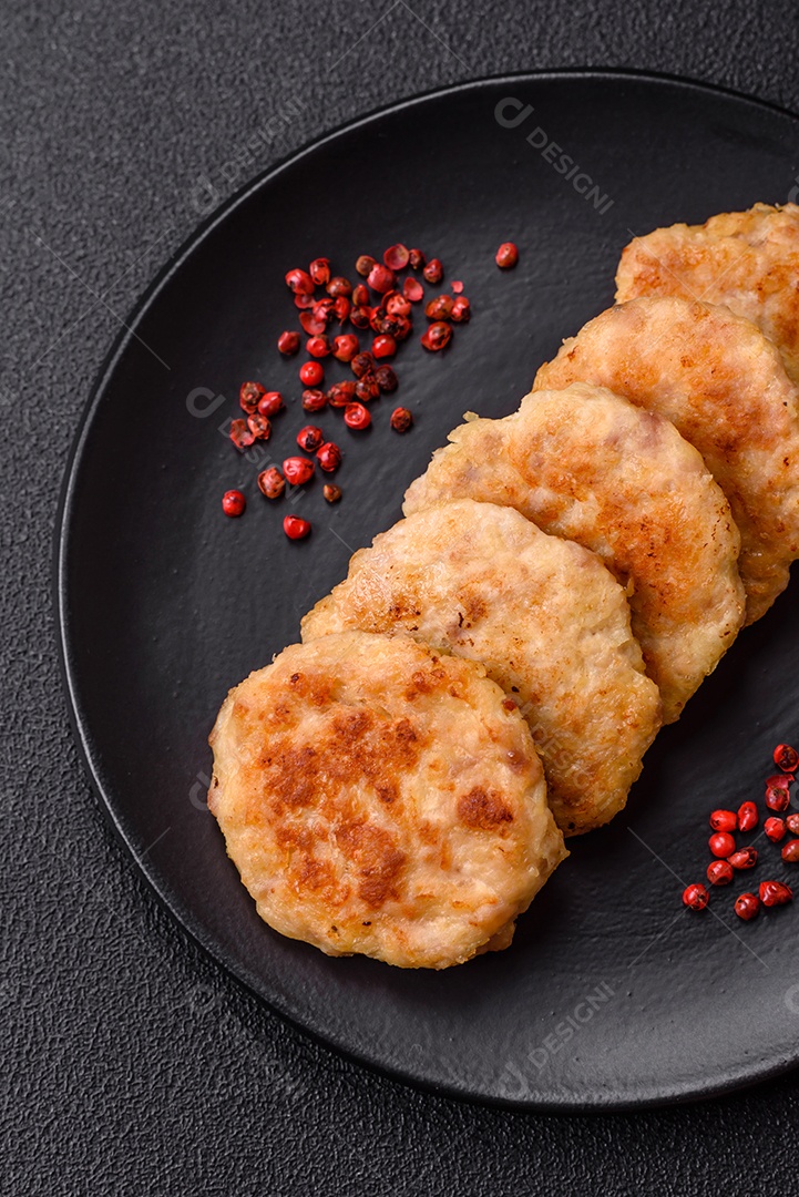 Deliciosas costeletas de peixe picado frito fresco com especiarias e ervas sobre um fundo escuro de concreto