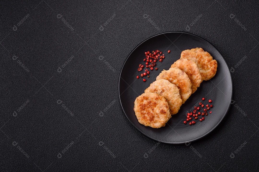 Deliciosas costeletas de peixe picado frito fresco com especiarias e ervas sobre um fundo escuro de concreto