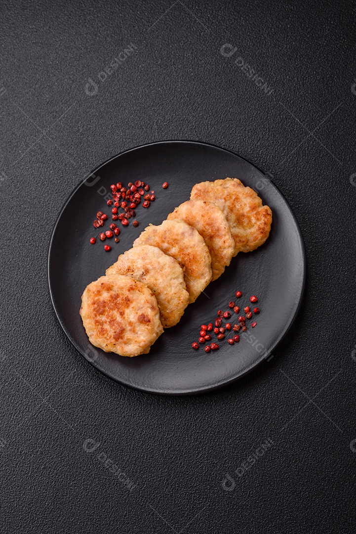 Deliciosas costeletas de peixe picado frito fresco com especiarias e ervas sobre um fundo escuro de concreto