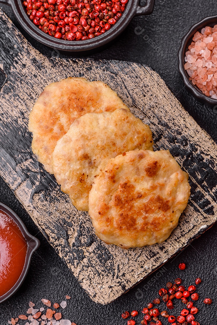Deliciosas costeletas de peixe picado frito fresco com especiarias e ervas sobre um fundo escuro de concreto