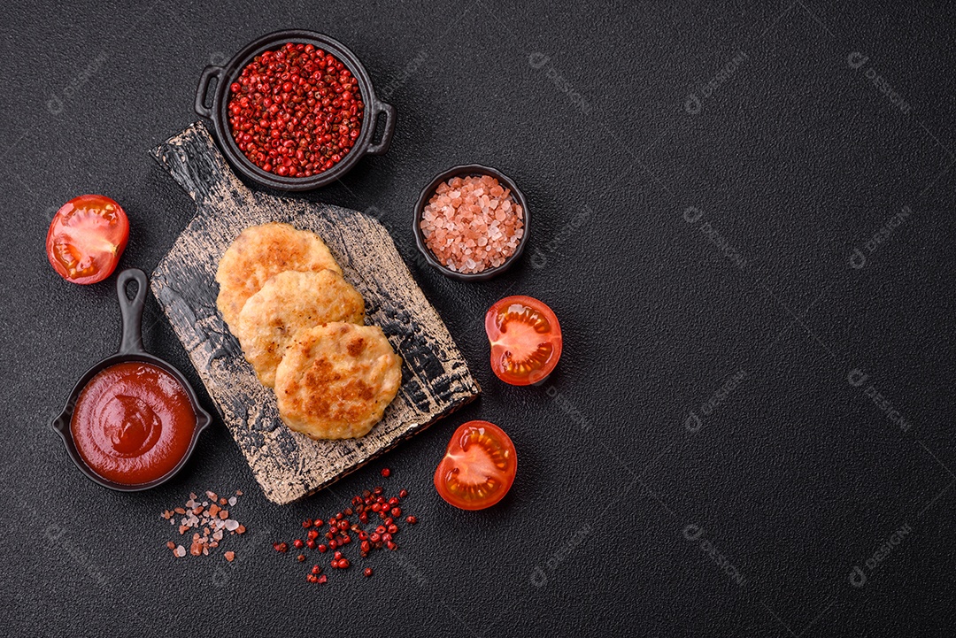 Deliciosas costeletas de peixe picado frito fresco com especiarias e ervas sobre um fundo escuro de concreto