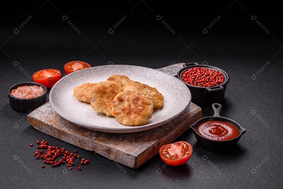 Deliciosas costeletas de peixe picado frito fresco com especiarias e ervas sobre um fundo escuro de concreto