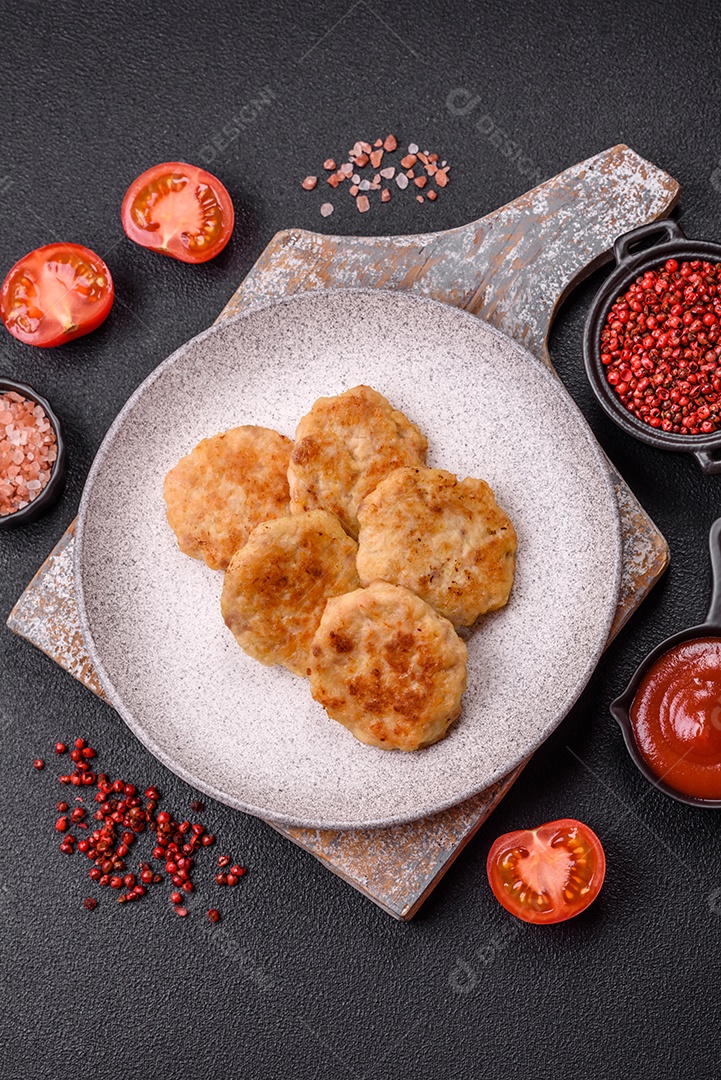 Deliciosas costeletas de peixe picado frito fresco com especiarias e ervas sobre um fundo escuro de concreto