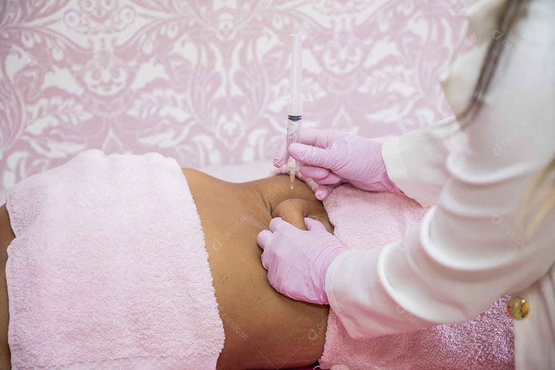 Esteticista aplicando procedimento na barriga da cliente