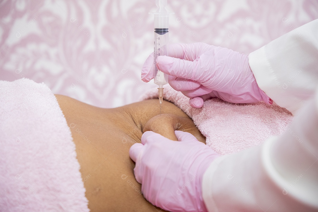 Esteticista aplicando procedimento na barriga da cliente