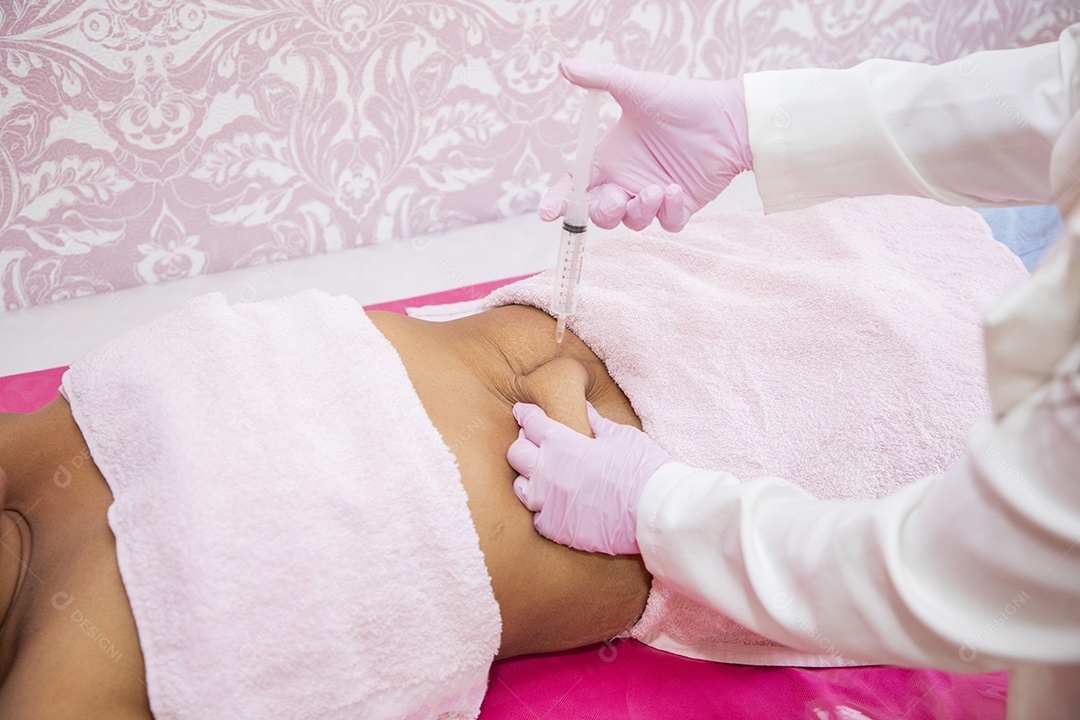 Esteticista aplicando procedimento na barriga da cliente