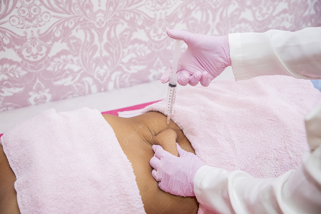 Esteticista aplicando procedimento na barriga da cliente