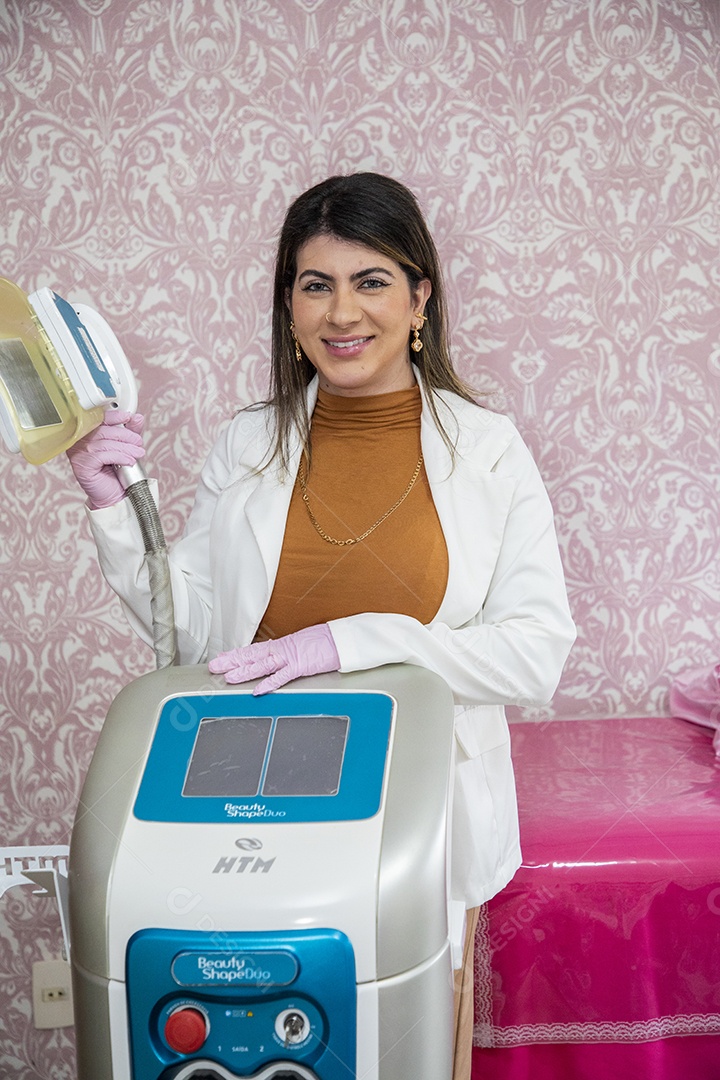 Esteticista sorrindo e segurando aparelho de trabalho nas mãos