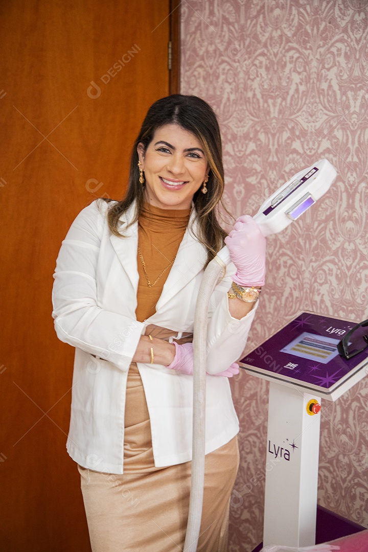 Esteticista linda segurando aparelho para foto