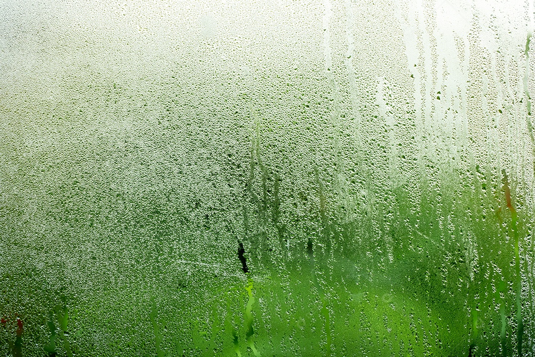 O vapor de água se forma no vidro atrás do fundo verde natural