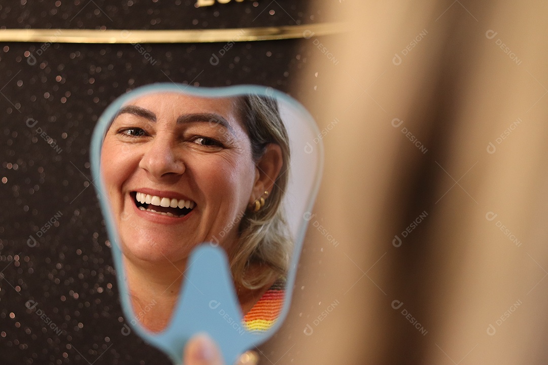 Bela mulher branca sorridente se olhando em espelho sobre fundo isolado