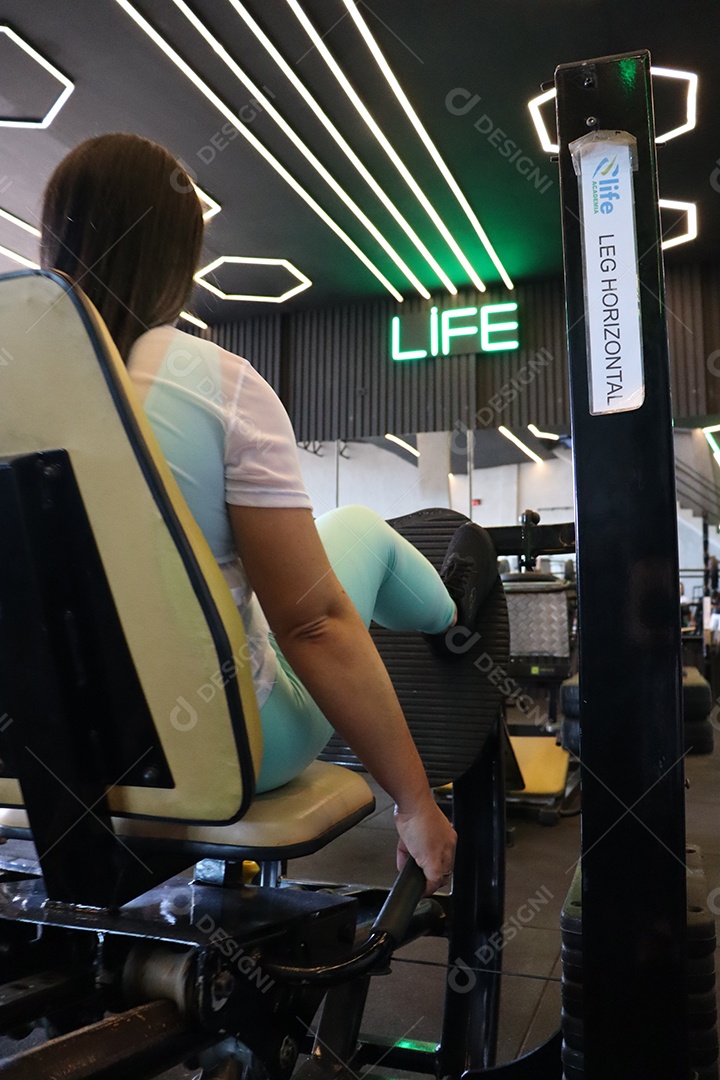 Bela mulher fazendo exercicíos sobre uma academia