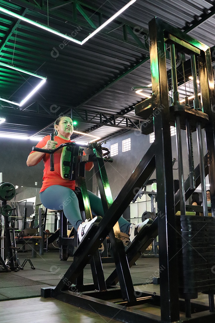 Bela mulher fazendo exercicíos sobre uma academia