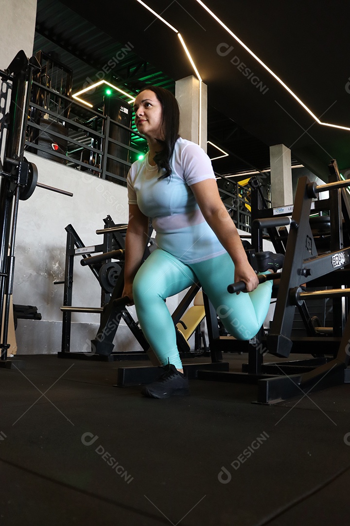 Bela mulher fazendo exercicíos sobre uma academia