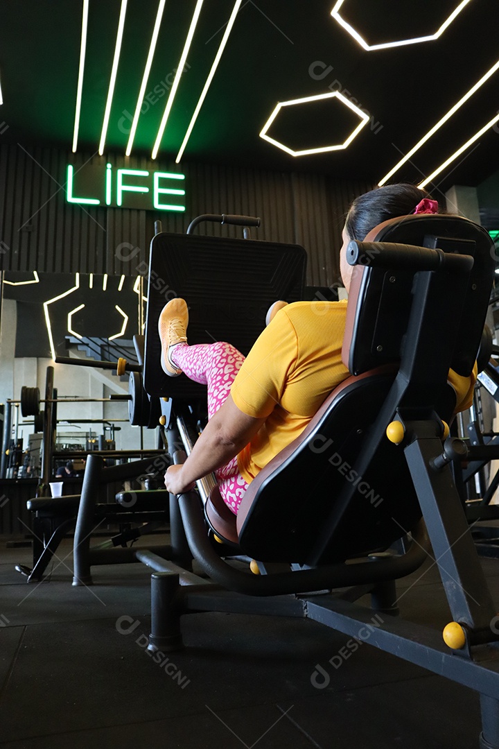 Bela mulher fazendo exercicíos sobre uma academia