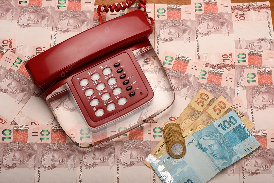 Telefone antigo sobre muitos dinheiros e moedas