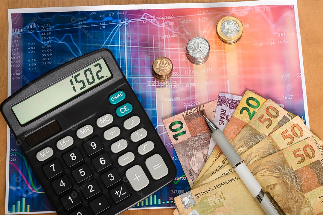 Folha de gráfico com calculadora e notas de dinheiro brasileiro