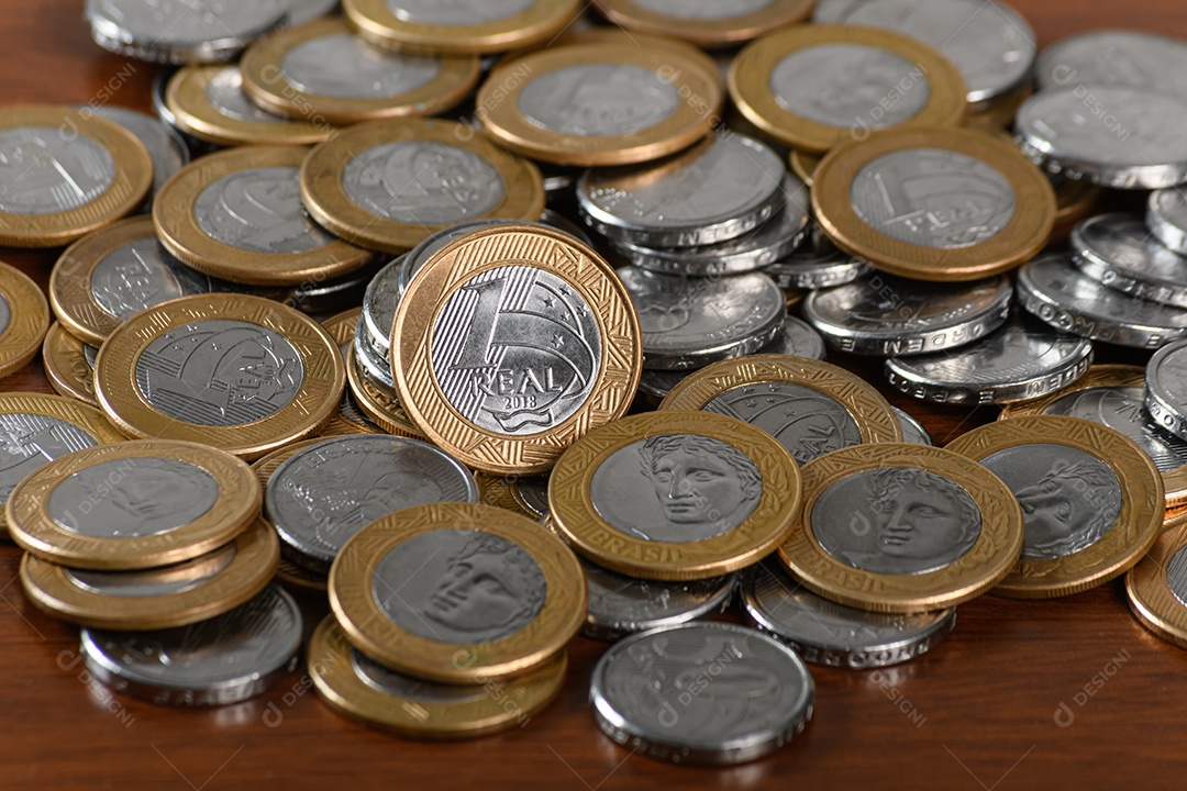 Moedas de um e cinquenta centavos sobre fundo de madeira